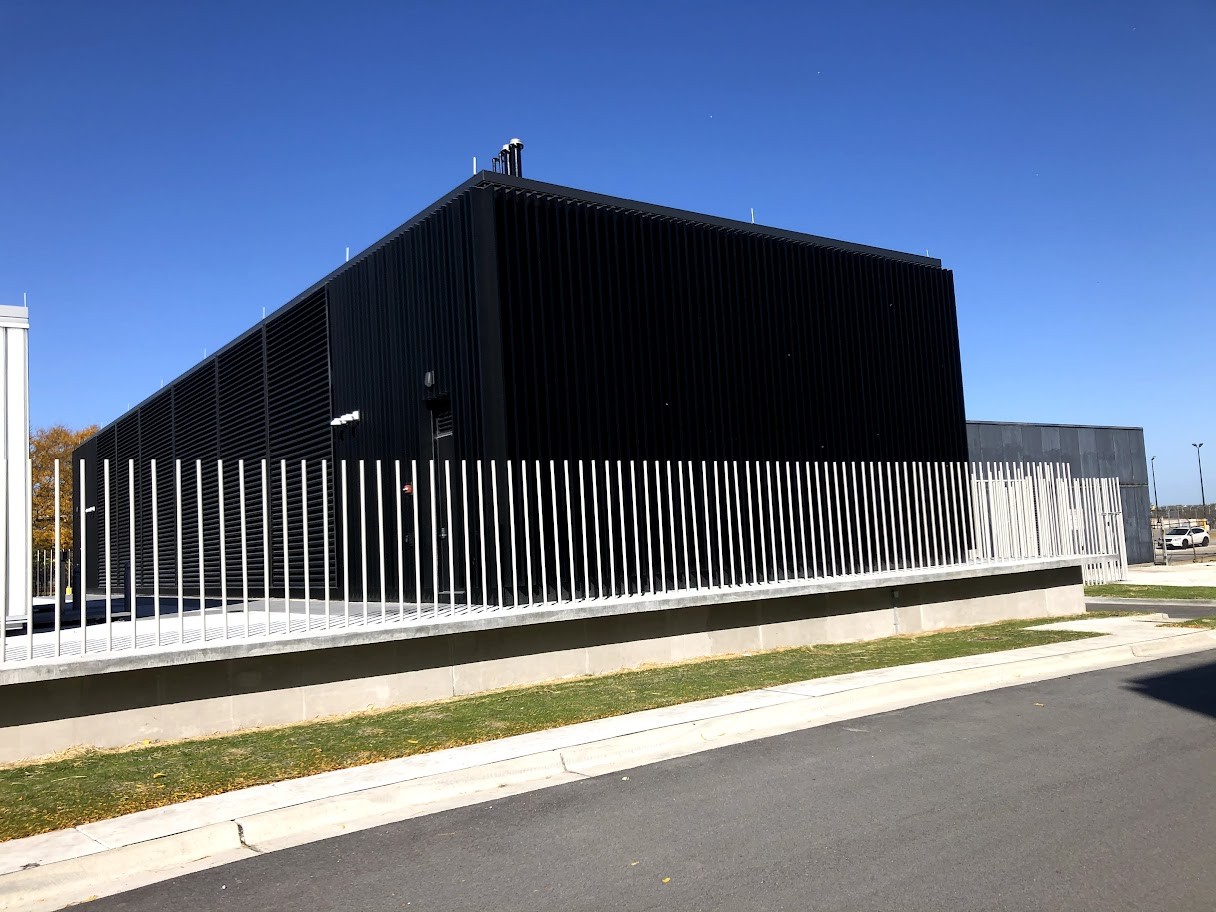 A black building with a fence around it